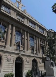 fachada casa central uc con palmeras y cristo sobre el edificio