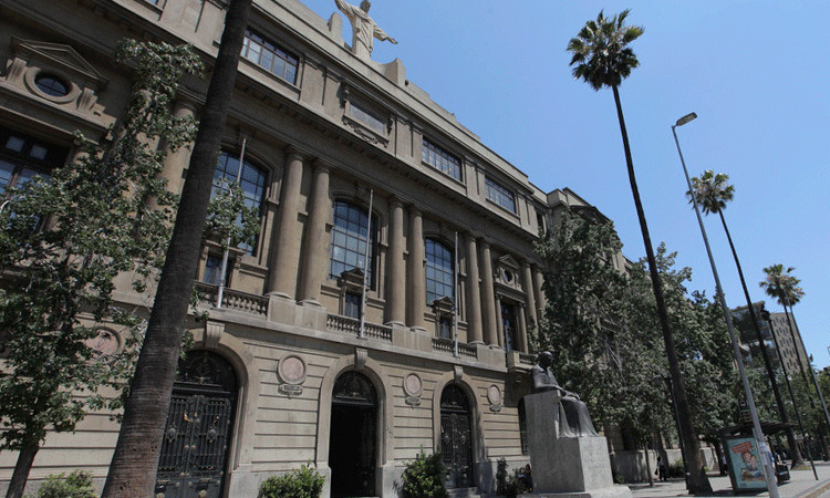 fachada casa central uc con palmeras y cristo sobre el edificio