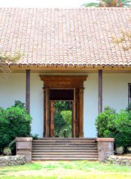 Casona blanca con árboles y arbustos