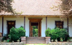 Casona blanca con árboles y arbustos