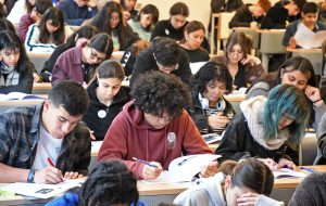 Grupo de hombres y mujeres rindiendo una prueba de papel.