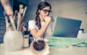 Mujer concentrada revisando su pantalla del computador