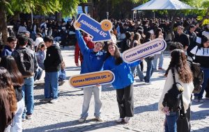 dos estudiantes sosteniendo letreros de admisión uc