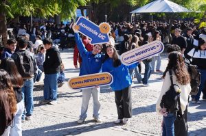 dos estudiantes sosteniendo letreros de admisión uc